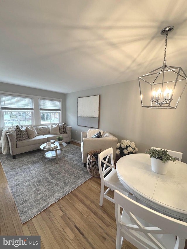 dining room with wood finished floors and a notable chandelier