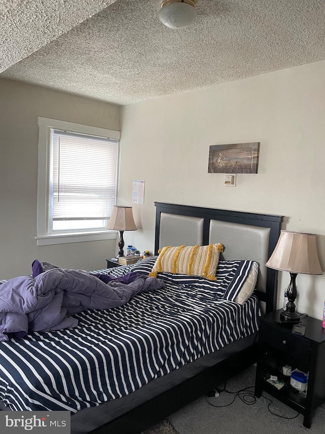 bedroom featuring carpet flooring and a textured ceiling