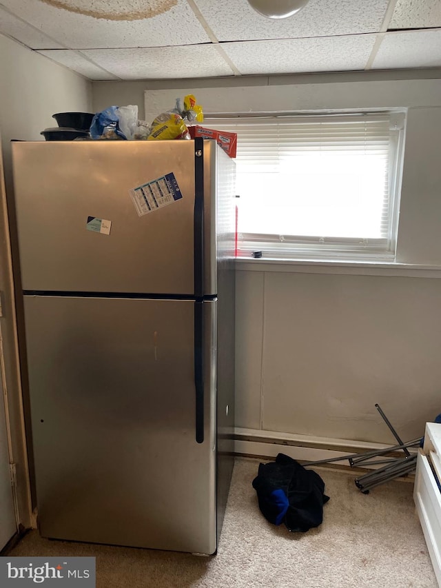 kitchen featuring carpet, a drop ceiling, and freestanding refrigerator