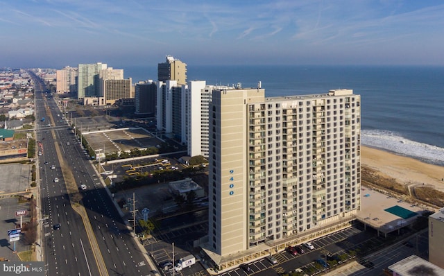 aerial view featuring a view of the beach, a water view, and a city view