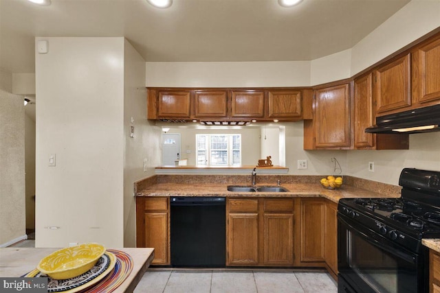 kitchen with black appliances, under cabinet range hood, brown cabinetry, and a sink