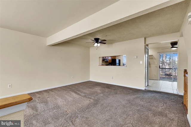 unfurnished living room featuring beamed ceiling, baseboards, a ceiling fan, and carpet flooring