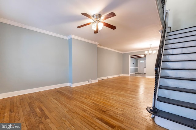 unfurnished living room featuring ornamental molding, baseboards, stairway, and light wood finished floors