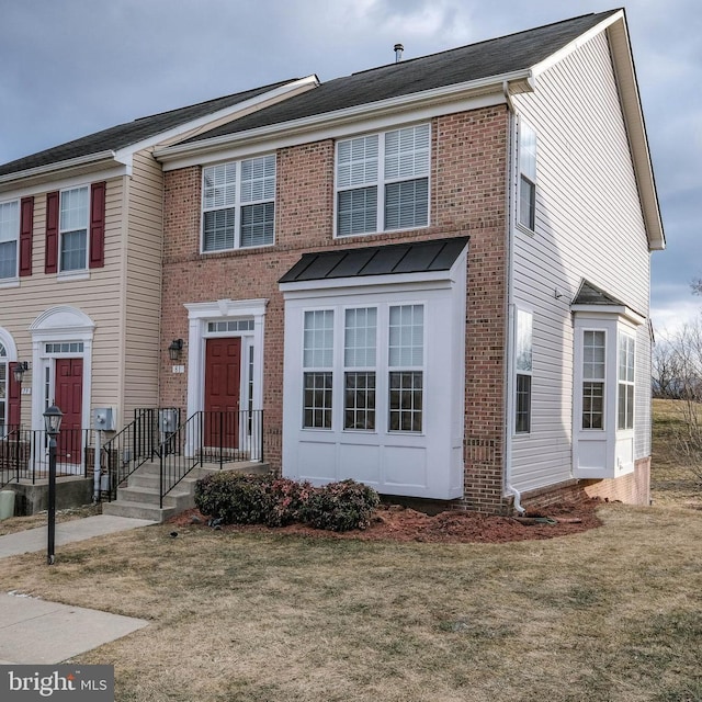 view of property featuring a front yard and brick siding