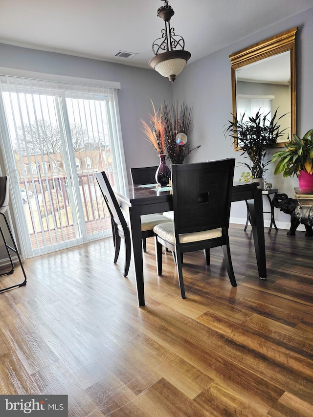 dining space with visible vents, baseboards, and wood finished floors