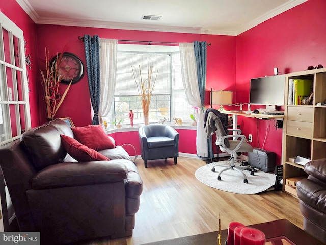 living room featuring wood finished floors, visible vents, and crown molding