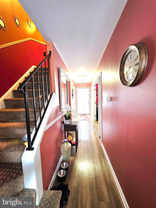 hall with baseboards, stairway, and wood finished floors