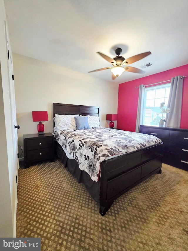 bedroom with carpet floors, ceiling fan, and visible vents