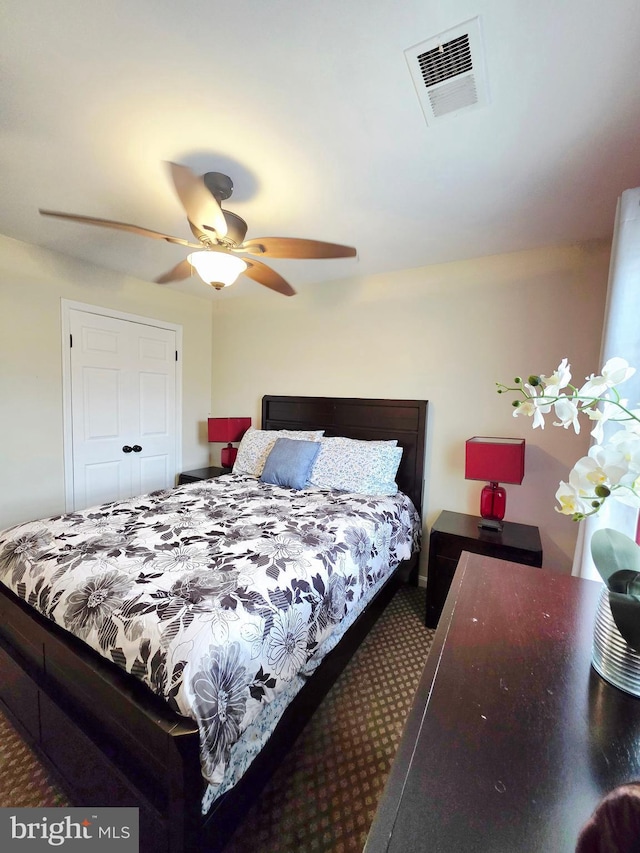 carpeted bedroom featuring visible vents and a ceiling fan