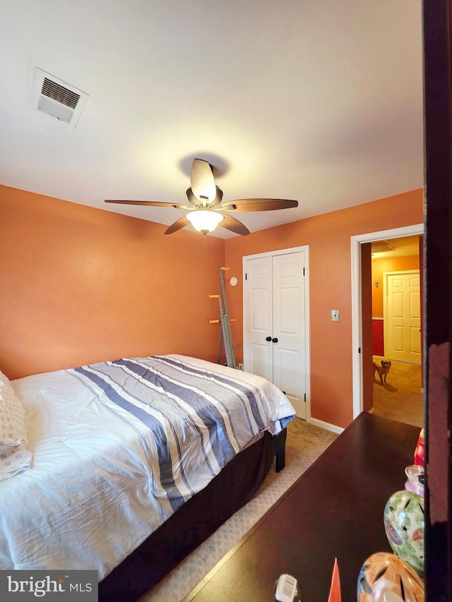 bedroom featuring a closet, visible vents, a ceiling fan, carpet flooring, and baseboards