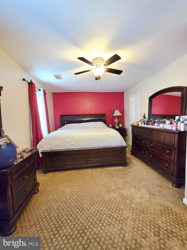 bedroom featuring ceiling fan, visible vents, and light colored carpet