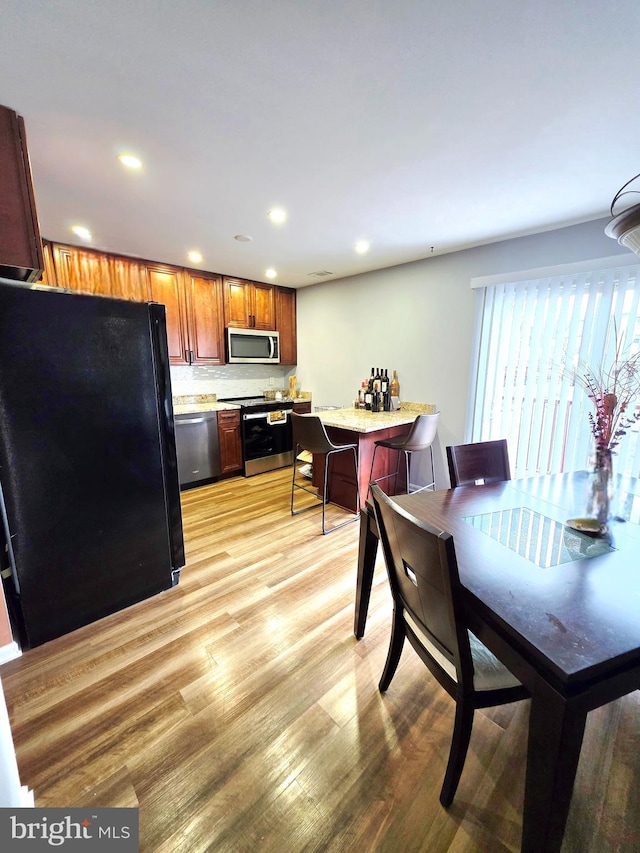 dining room featuring recessed lighting and light wood finished floors