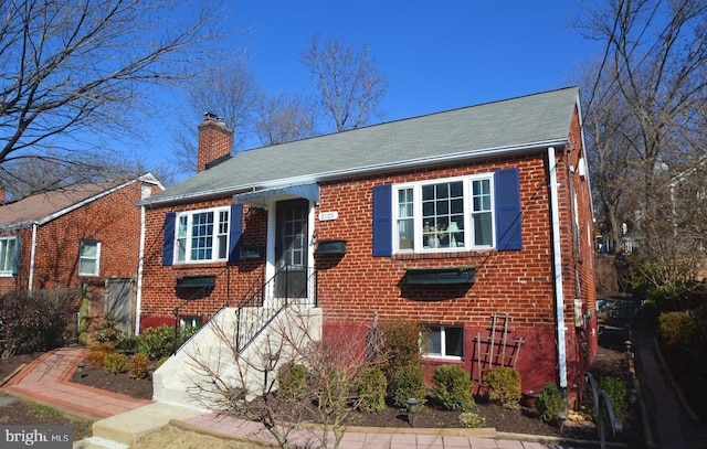 view of front of house with brick siding and a chimney