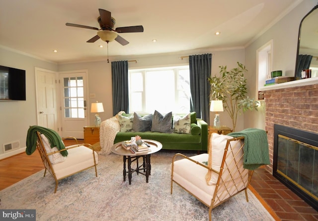 living area with recessed lighting, visible vents, ornamental molding, a brick fireplace, and baseboards