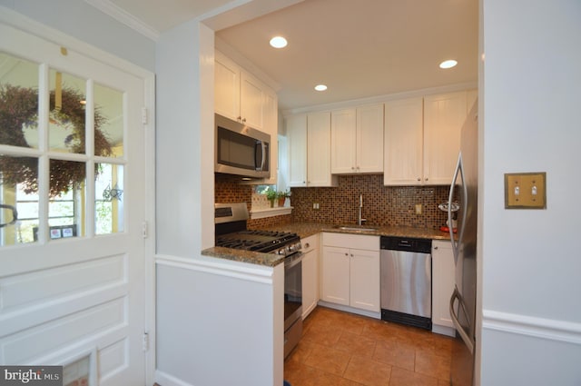 kitchen featuring appliances with stainless steel finishes, white cabinets, and dark stone countertops