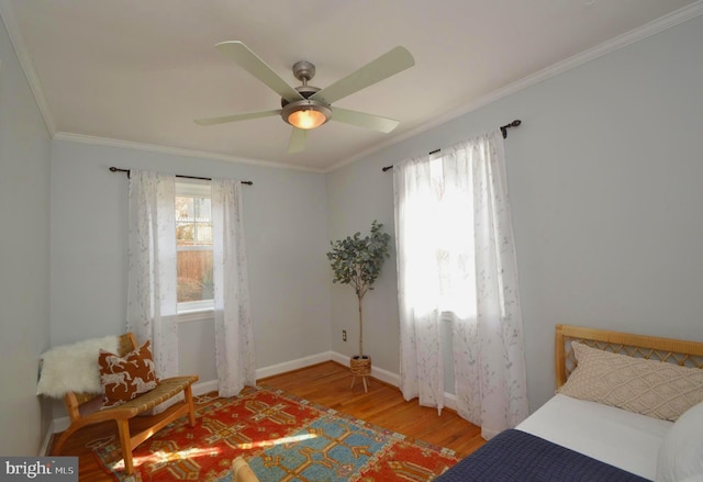 bedroom with ornamental molding, light wood-style flooring, baseboards, and a ceiling fan