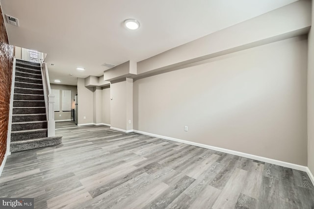 interior space with stairs, wood finished floors, visible vents, and baseboards