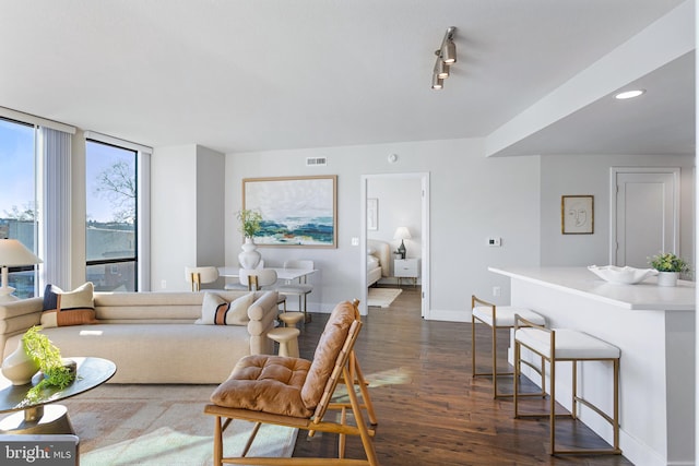 living room featuring visible vents, baseboards, and dark wood finished floors