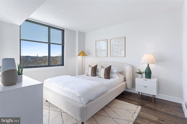 bedroom featuring dark wood-style floors and baseboards