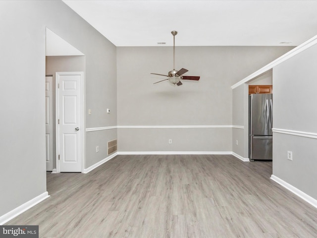 spare room with baseboards, visible vents, and light wood-style floors