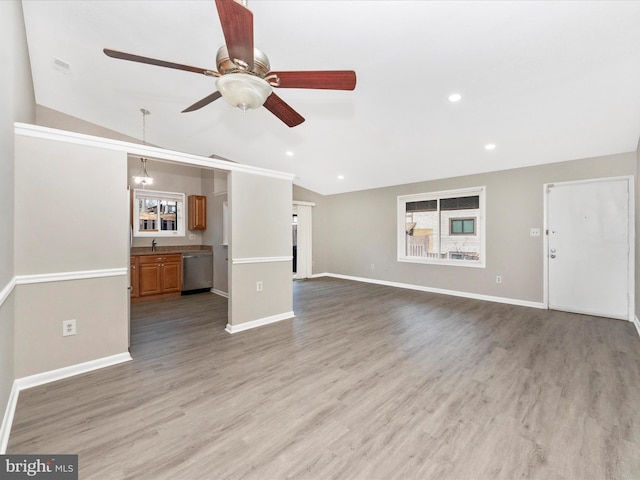 unfurnished living room with lofted ceiling, baseboards, wood finished floors, and recessed lighting