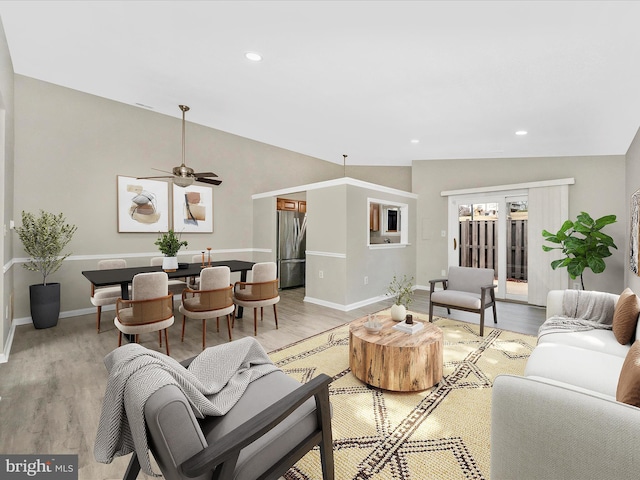 living area featuring light wood-type flooring, vaulted ceiling, and recessed lighting