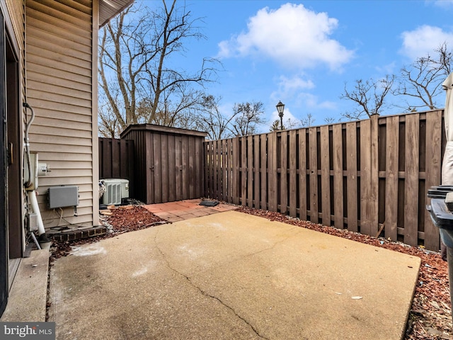 view of patio / terrace with a storage shed, an outbuilding, a fenced backyard, and central air condition unit