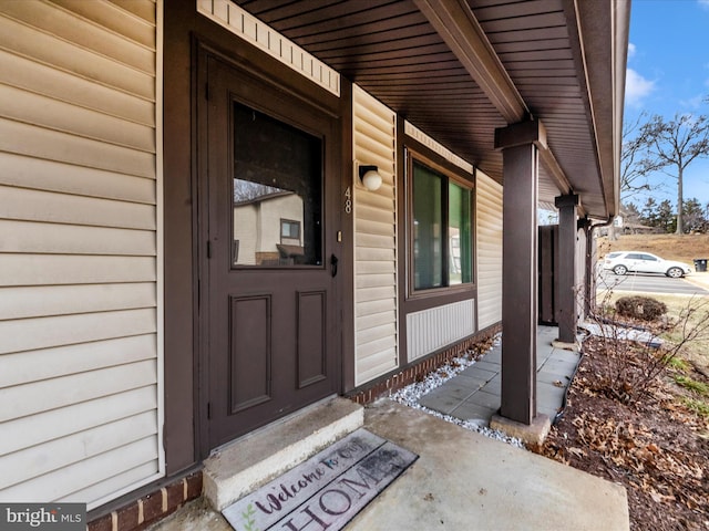 view of exterior entry featuring covered porch