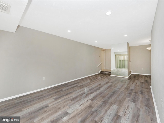 unfurnished room featuring baseboards, visible vents, wood finished floors, and recessed lighting