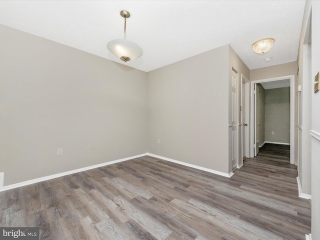 spare room with wood finished floors and baseboards