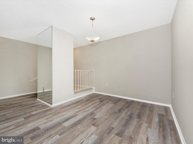 empty room with baseboards and wood finished floors