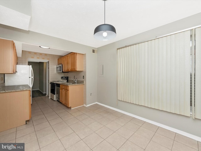 kitchen with stainless steel microwave, light countertops, range with electric stovetop, and light tile patterned flooring