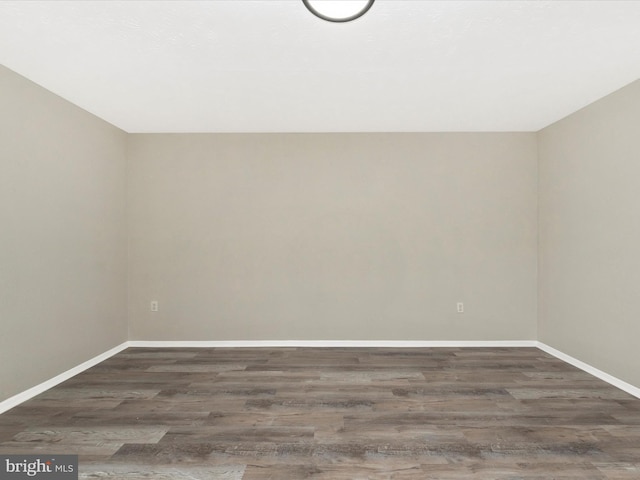 bonus room featuring baseboards and dark wood-style flooring