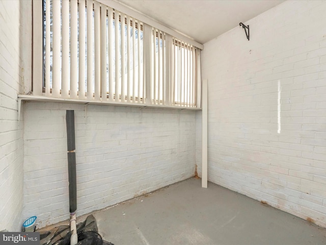 clothes washing area featuring brick wall