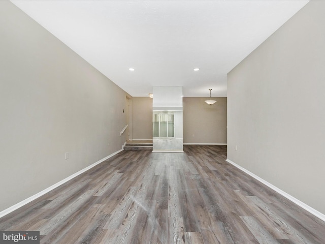 empty room featuring recessed lighting, baseboards, and wood finished floors