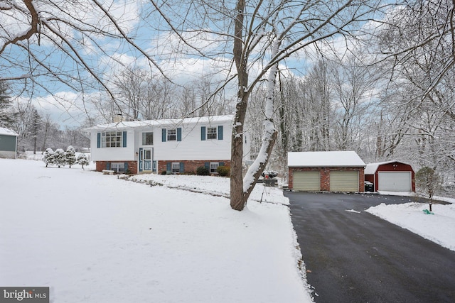 bi-level home with a garage, brick siding, an outdoor structure, and a chimney