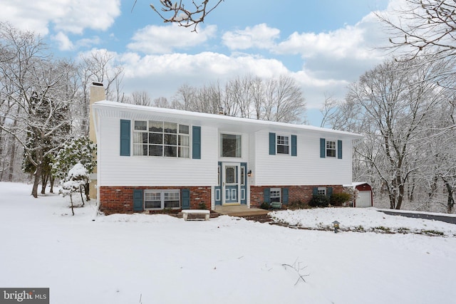 split foyer home featuring brick siding and a chimney