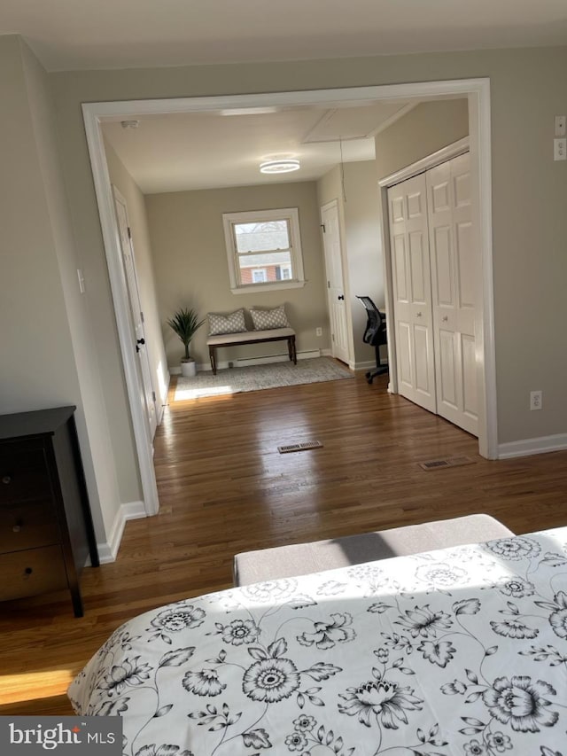 hall featuring dark wood finished floors, attic access, and baseboards