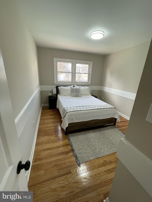 bedroom featuring baseboards and wood finished floors