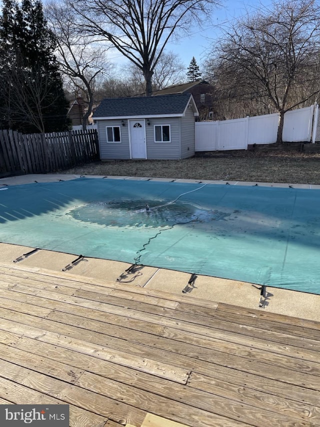 view of pool with an outbuilding, a fenced backyard, and a fenced in pool