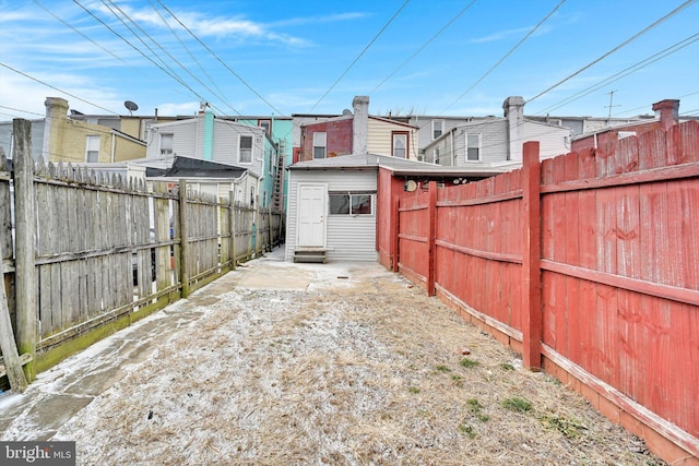 view of yard with entry steps, a fenced backyard, and a residential view