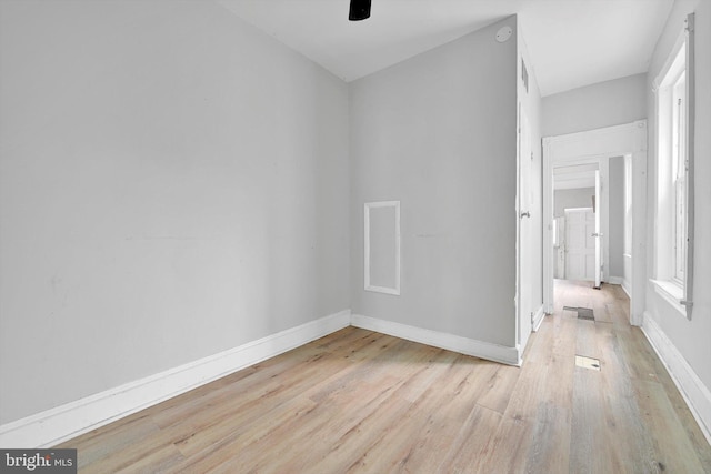 spare room featuring light wood-style flooring, baseboards, and ceiling fan