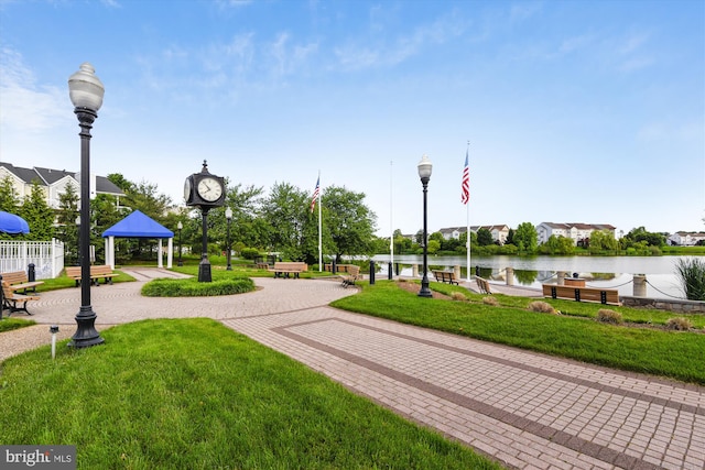 surrounding community with a water view, a lawn, and a gazebo