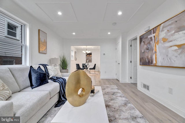 living area with a chandelier, light wood-style flooring, recessed lighting, visible vents, and baseboards