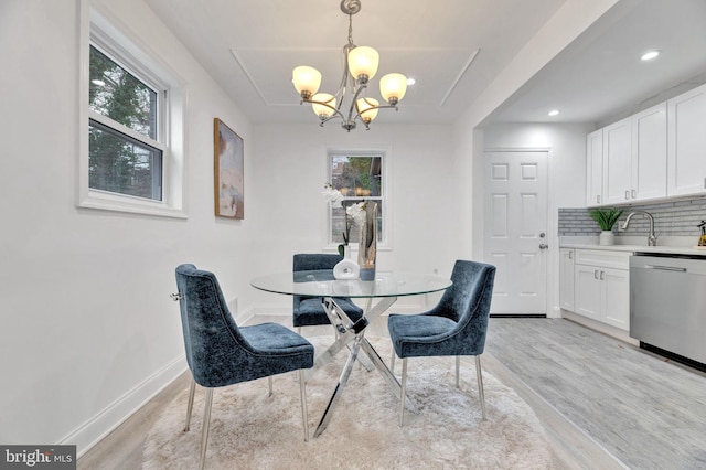 dining space with a notable chandelier, recessed lighting, light wood-type flooring, and baseboards