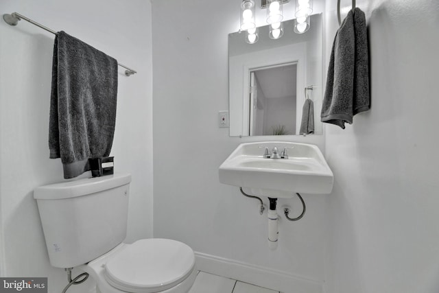 bathroom with a sink, tile patterned flooring, toilet, and baseboards