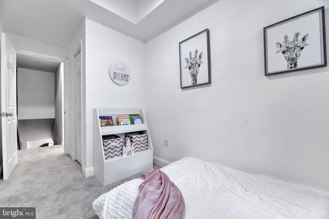 bedroom featuring light carpet and baseboards