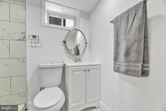 bathroom with toilet, vanity, and baseboards