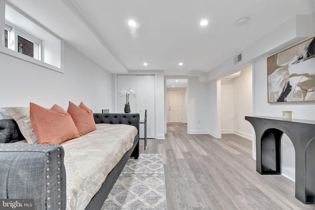 living area with light wood-style floors, baseboards, visible vents, and recessed lighting