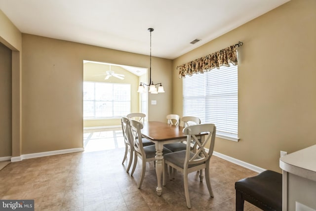 dining space featuring ceiling fan with notable chandelier, visible vents, and baseboards